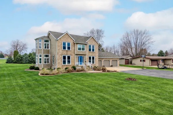a front view of a house with a garden and trees
