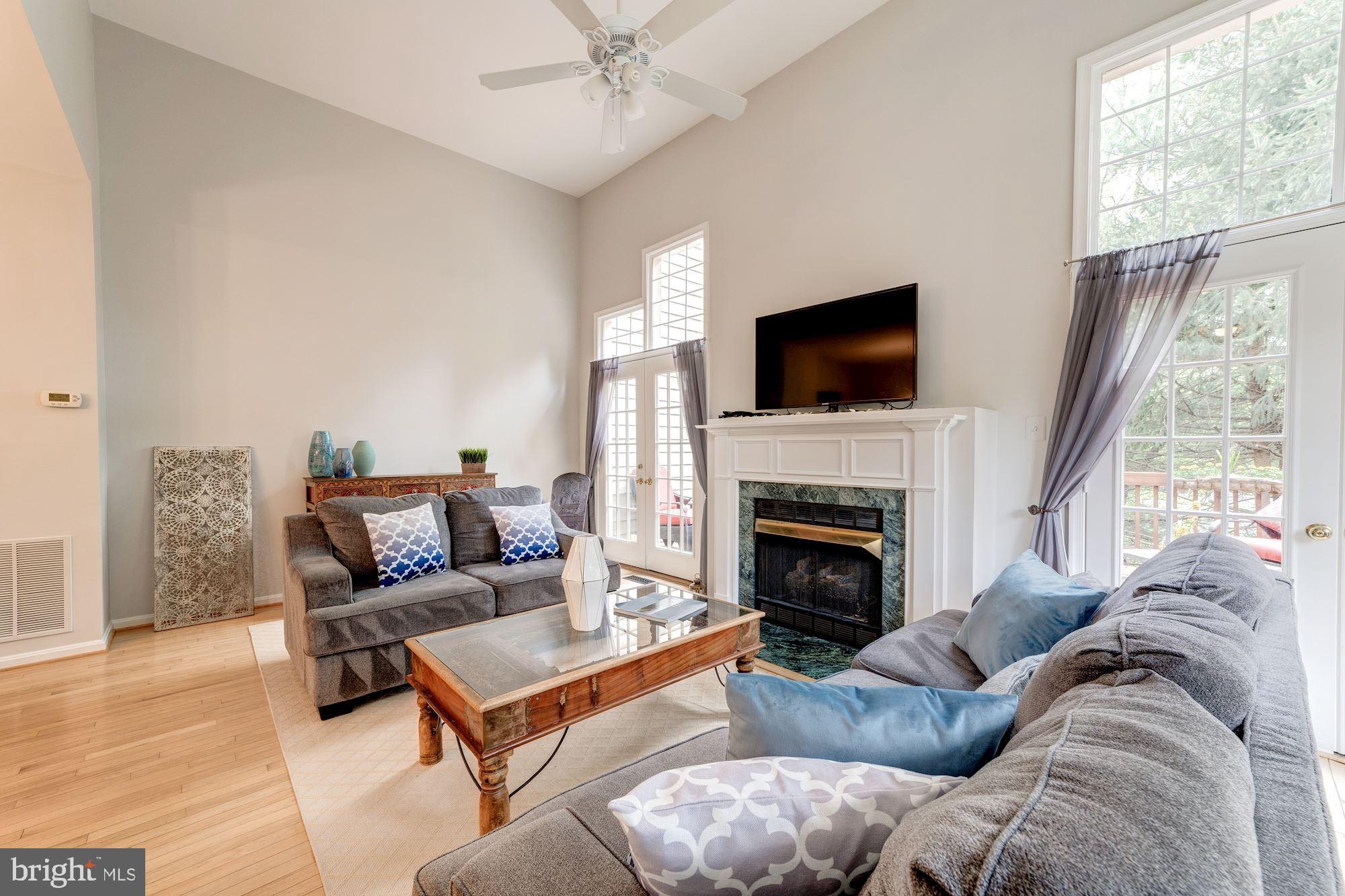 1283 Weatherstone Court Reston, VA 20194 - Photo 14 of 38 a living room with furniture a flat screen tv and a fireplace