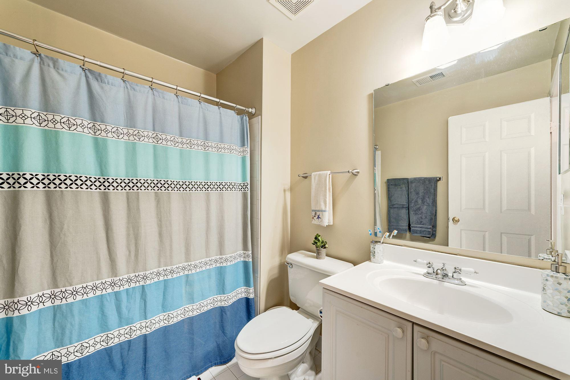 1283 Weatherstone Court Reston, VA 20194 - Photo 25 of 38 a bathroom with a sink a toilet and shower curtain