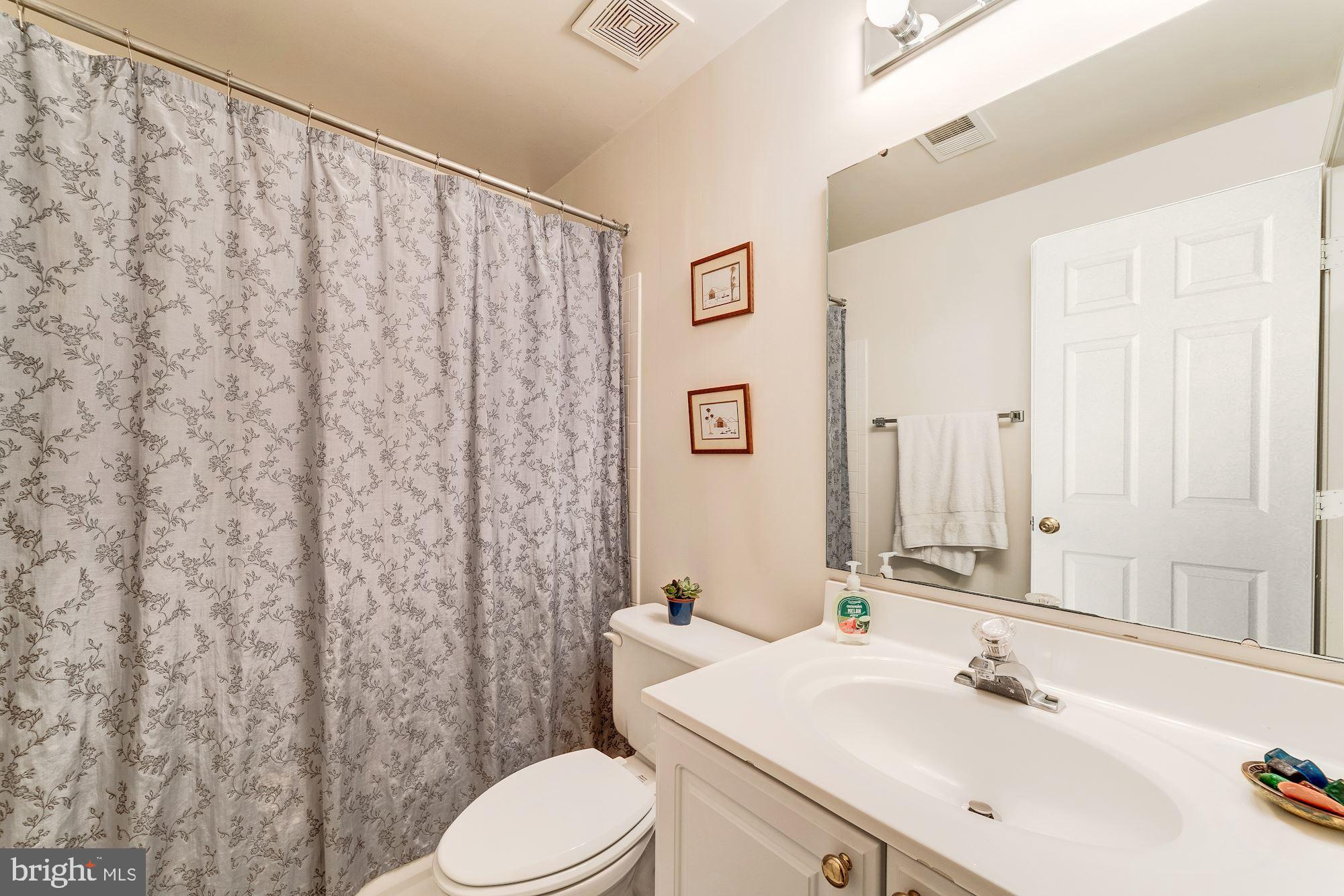 1283 Weatherstone Court Reston, VA 20194 - Photo 30 of 38 a bathroom with a sink a toilet and shower curtain