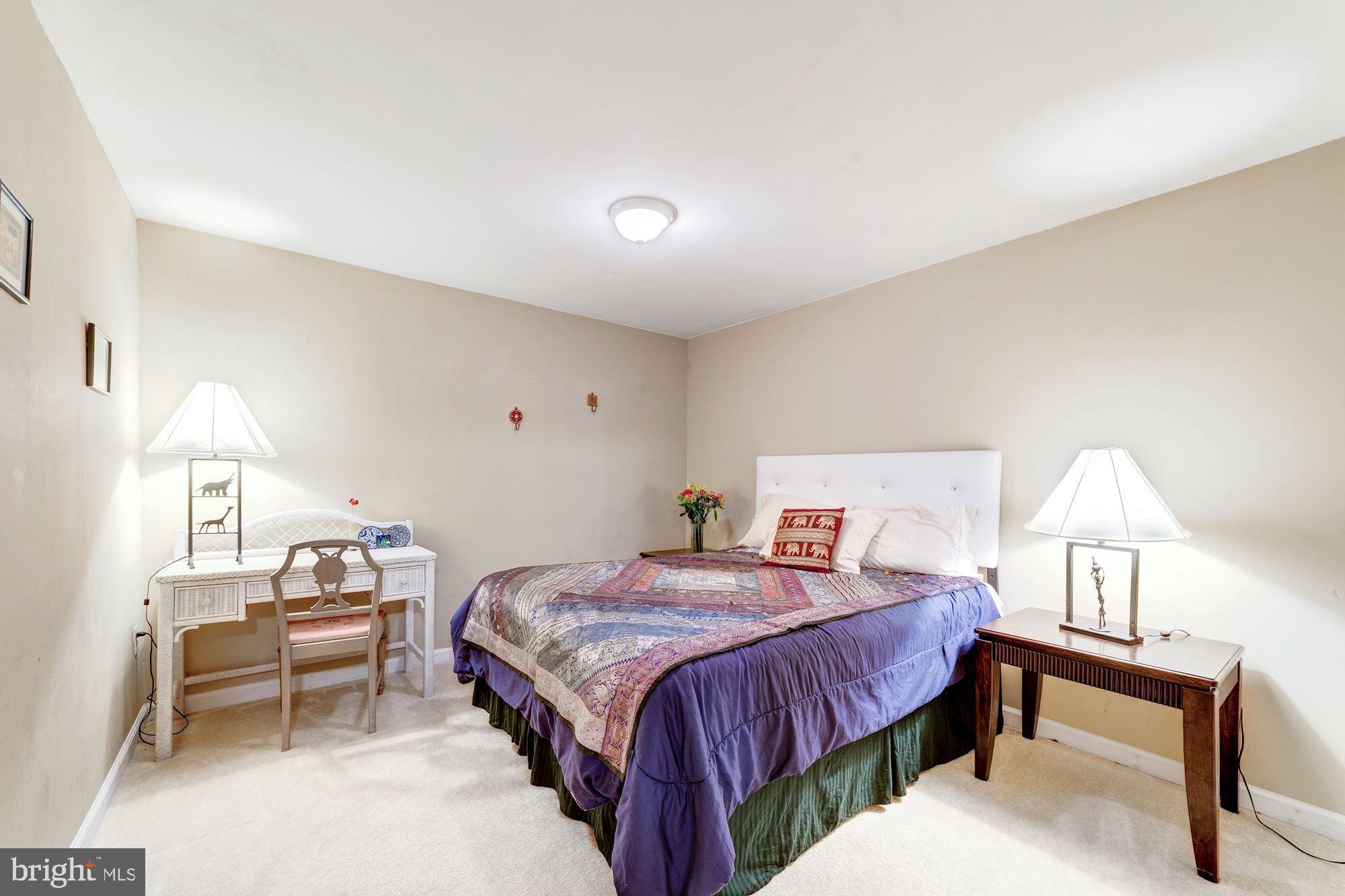 1283 Weatherstone Court Reston, VA 20194 - Photo 32 of 38 a bedroom with a bed and a lamp on table