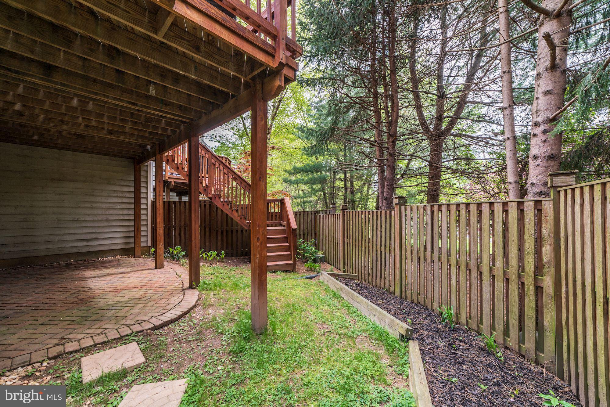 1283 Weatherstone Court Reston, VA 20194 - Photo 34 of 38 a view of a backyard with wooden fence and a large tree