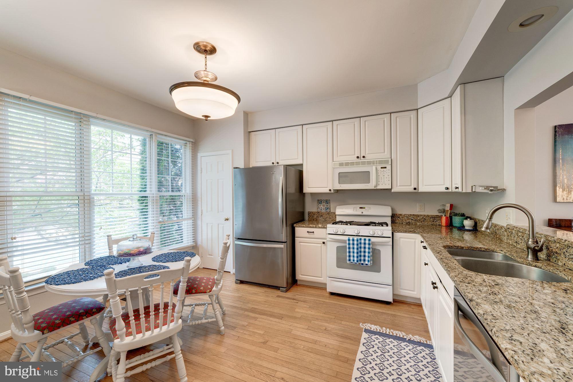 1283 Weatherstone Court Reston, VA 20194 - Photo 5 of 38 a kitchen with a center island appliances cabinets and a large window