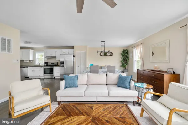 a living room with furniture and a view of kitchen
