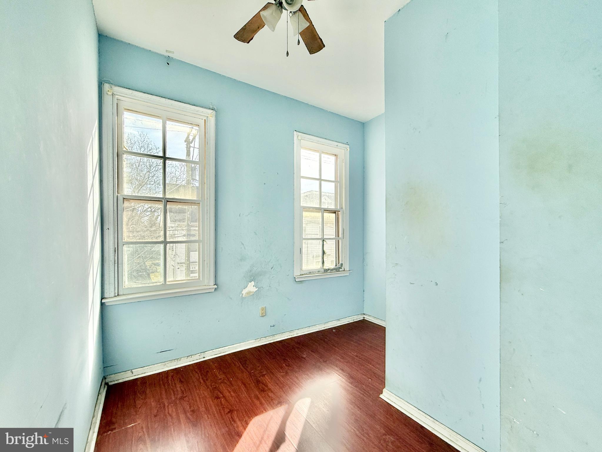 187 7th Street Salem, NJ 08079 - Photo 21 of 26 an empty room with wooden floor chandelier fan and windows