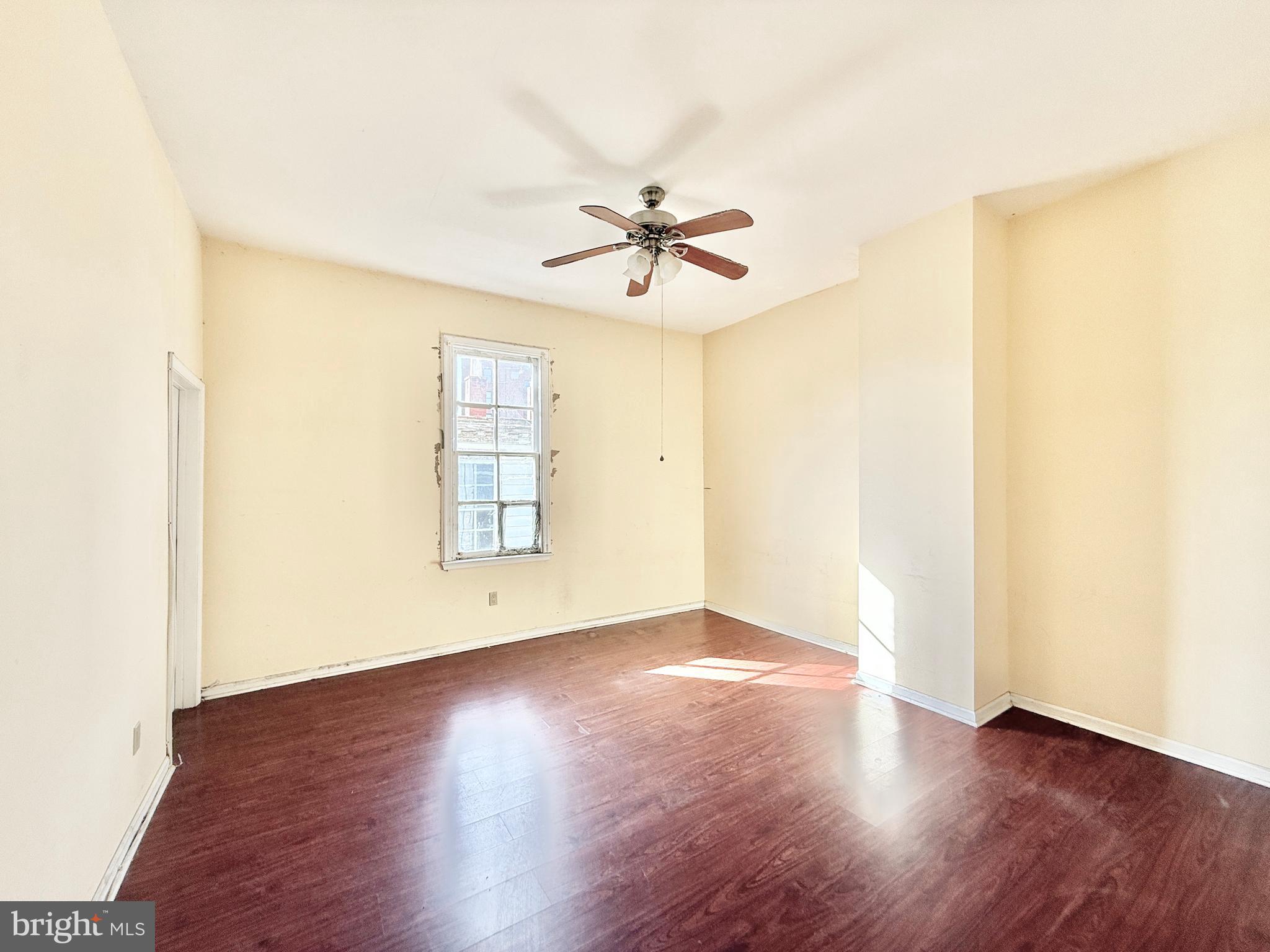 187 7th Street Salem, NJ 08079 - Photo 23 of 26 an empty room with wooden floor ceiling fan and windows