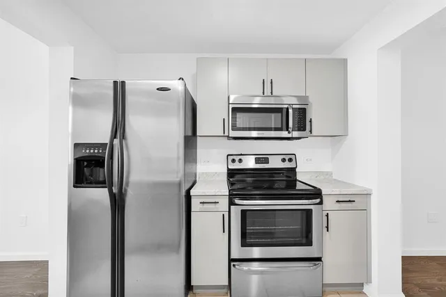 an empty room with ceiling fan and windows