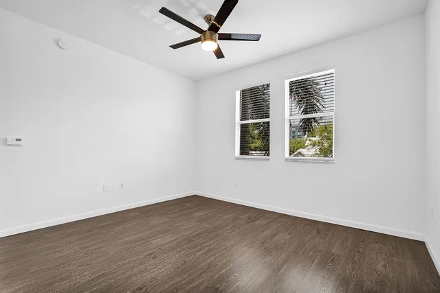 a view of an empty room with wooden floor