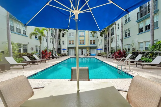 a view of a patio with a table and chairs under an umbrella