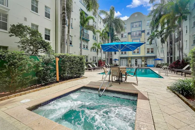 a view of a hallway with wooden floor and a bathroom