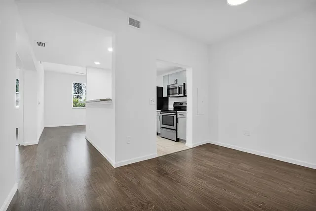 a view of kitchen with stainless steel appliances cabinets and wooden floor