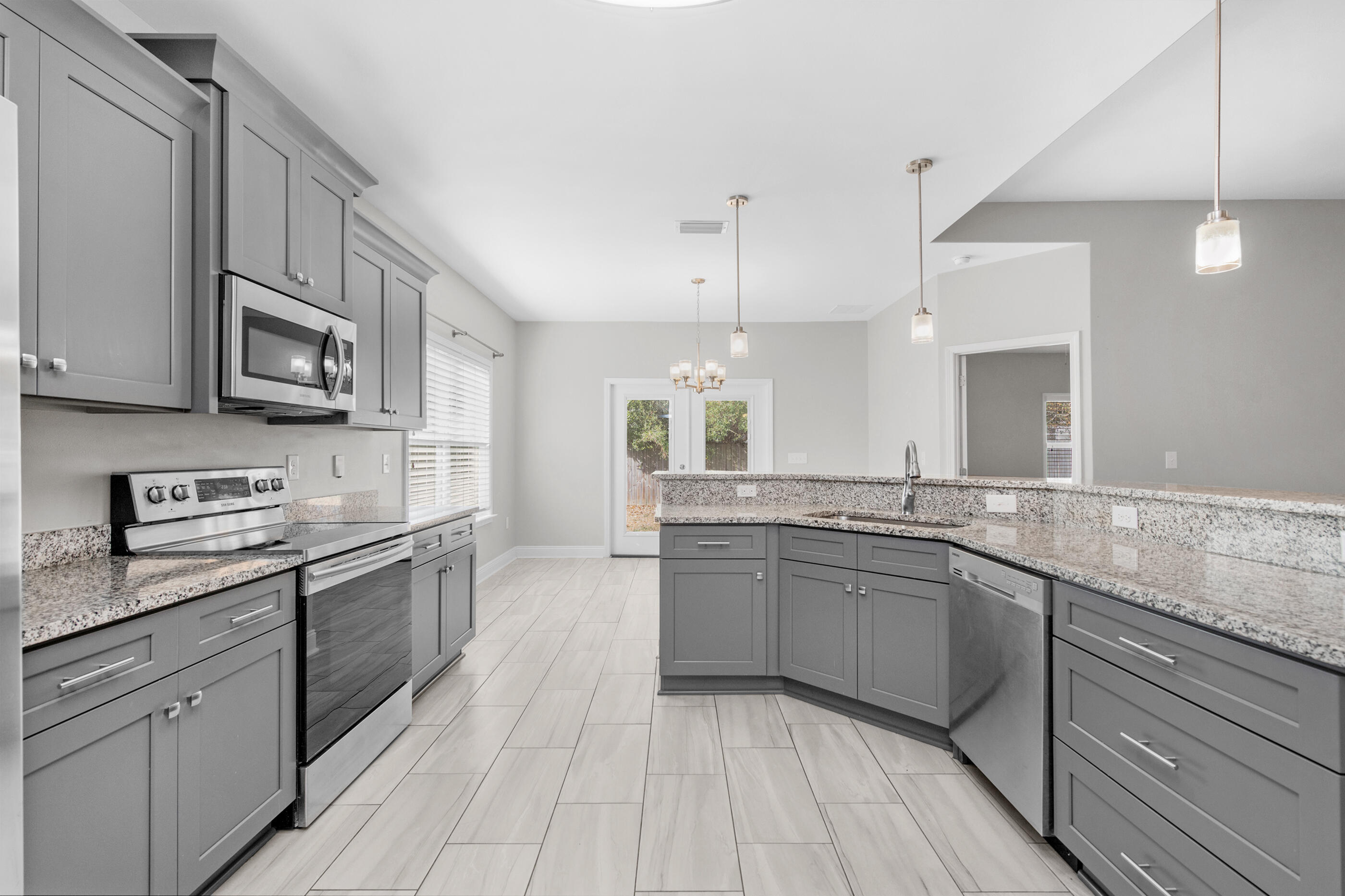 2285 Tom Street Navarre, FL 32566 - Photo 11 of 36 a large kitchen with stainless steel appliances granite countertop a stove sink and cabinets