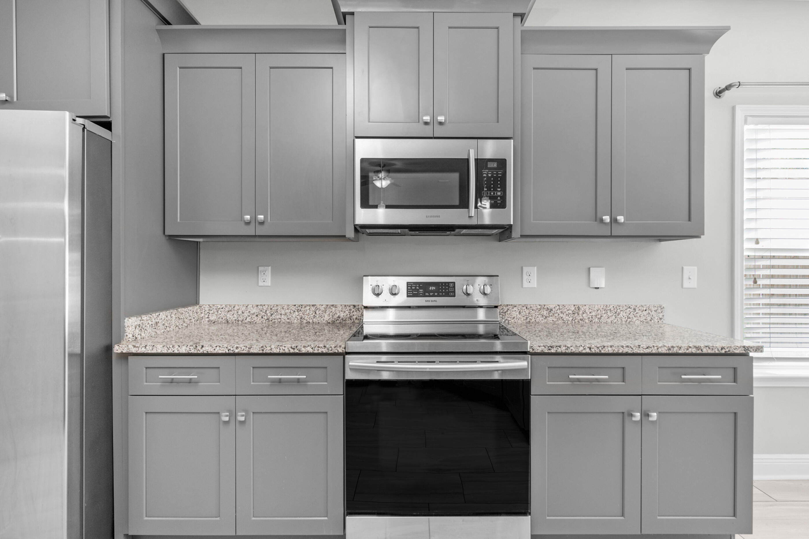 2285 Tom Street Navarre, FL 32566 - Photo 15 of 36 a kitchen with stainless steel appliances granite countertop white cabinets sink and a granite counter top