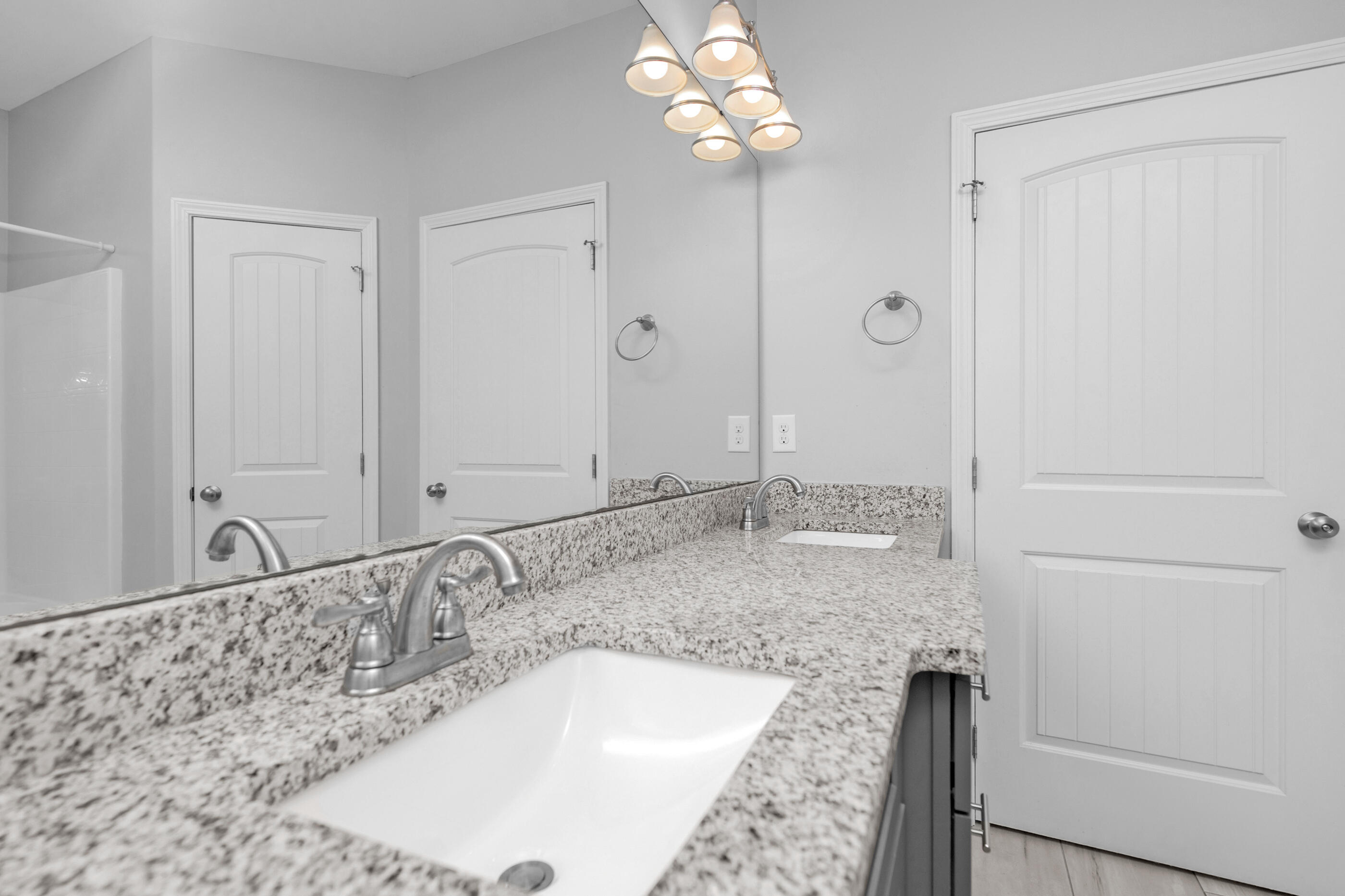 2285 Tom Street Navarre, FL 32566 - Photo 20 of 36 a bathroom with a granite countertop sink a mirror and shower