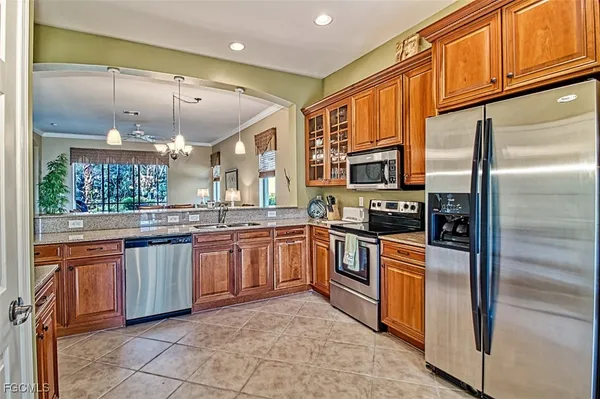 a kitchen with stainless steel appliances granite countertop a refrigerator a stove top oven and sink