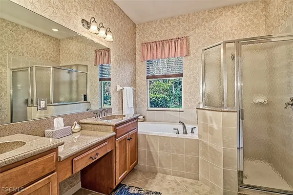 a bathroom with a double vanity sink mirror and shower