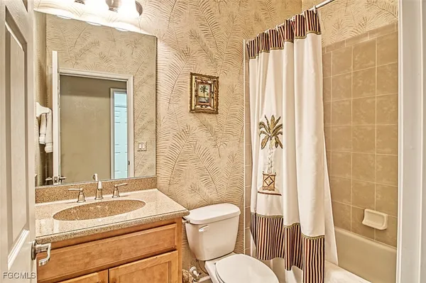 a bathroom with a granite countertop sink toilet a mirror and shower
