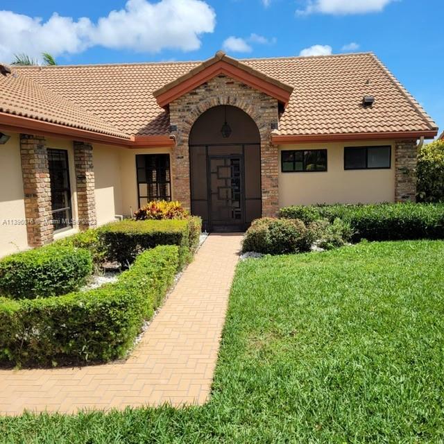 8380 Lords Place, Unit 8380 Boynton Beach, FL 33472 - Photo 2 of 21 a front view of a house with garden