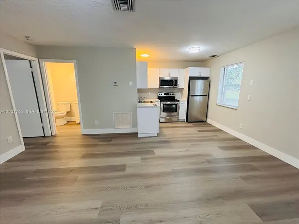 a view of a kitchen with a sink and a refrigerator