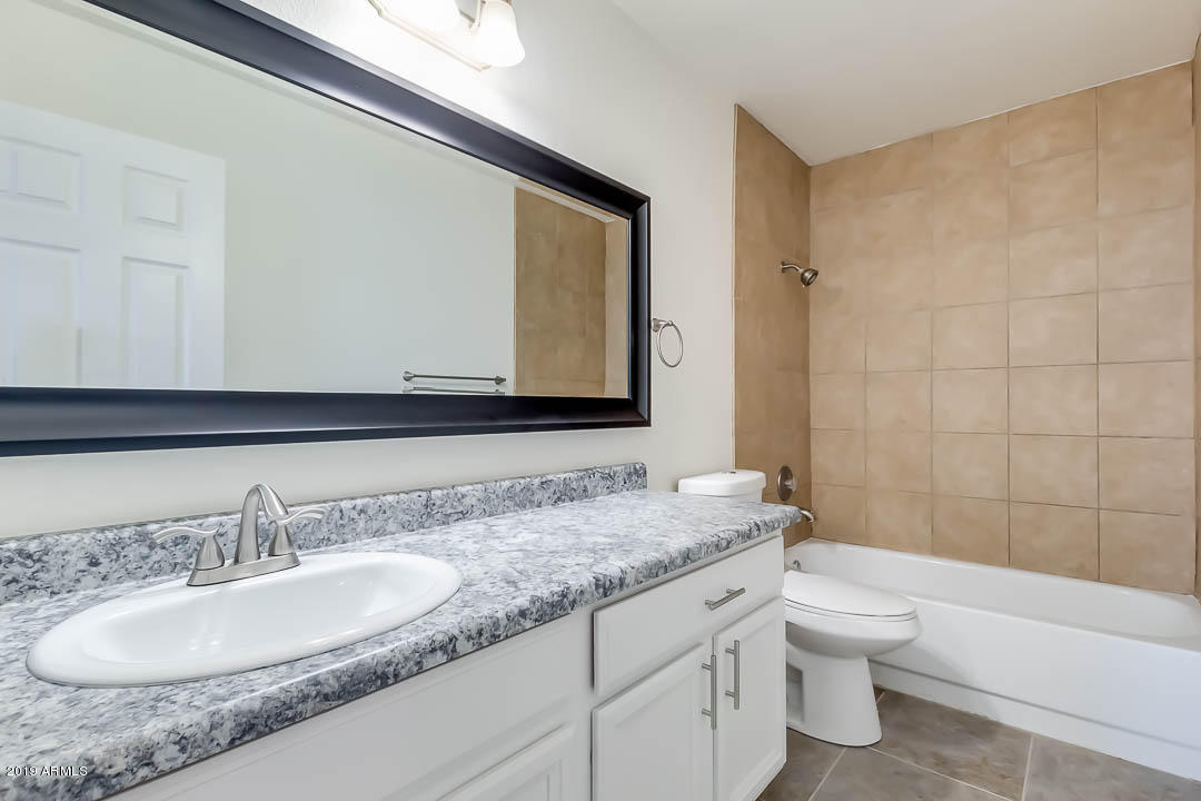 1860 East Inverness Avenue Mesa, AZ 85204 - Photo 19 of 29 a bathroom with a granite countertop sink a toilet and a bathtub