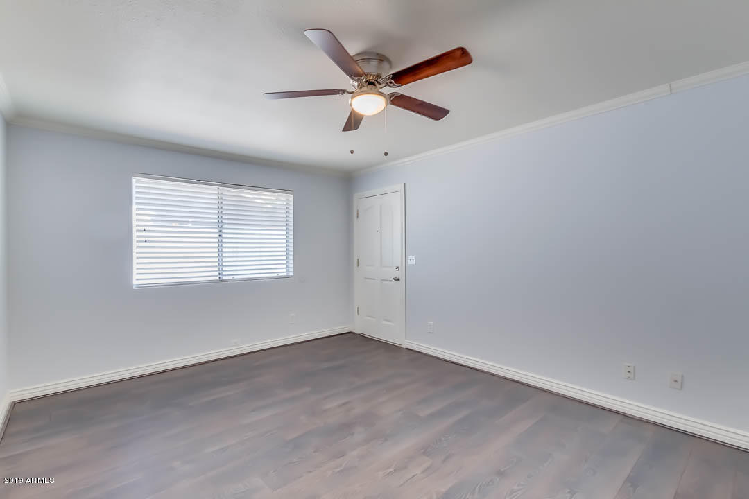 1860 East Inverness Avenue Mesa, AZ 85204 - Photo 7 of 29 an empty room with ceiling fan and windows