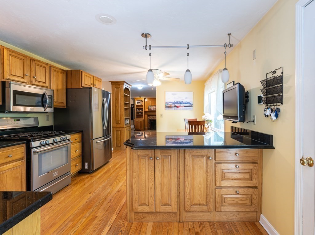 105 Warren Road Townsend, MA 01469 - Photo 5 of 37 a kitchen with granite countertop a refrigerator and microwave