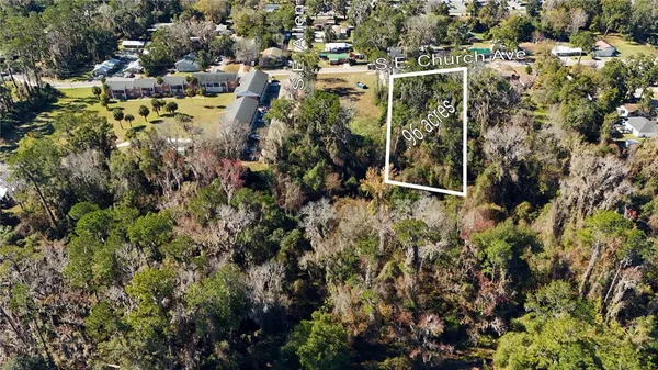 an aerial view of residential house with parking and yard