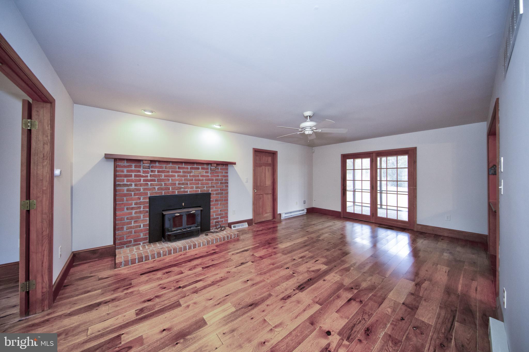 3044 Level Road Churchville, MD 21028 - Photo 20 of 52 an empty room with wooden floor fireplace and windows