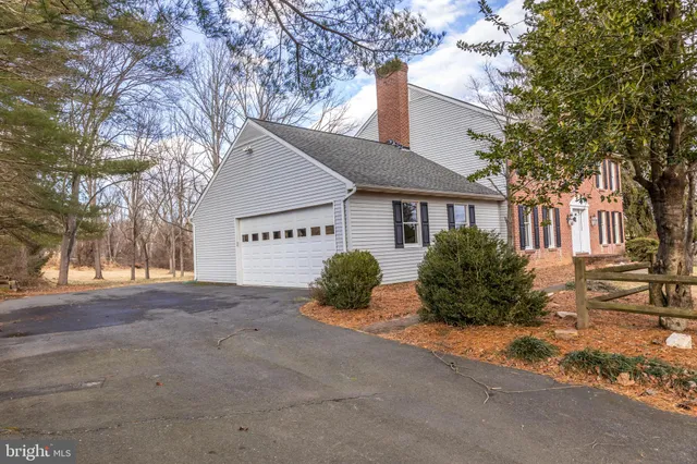 a view of a house with a yard and large tree