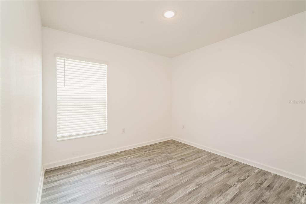 1473 Lucerne Loop Road Northeast Winter Haven, FL 33881 - Photo 19 of 25 an empty room with wooden floor and windows