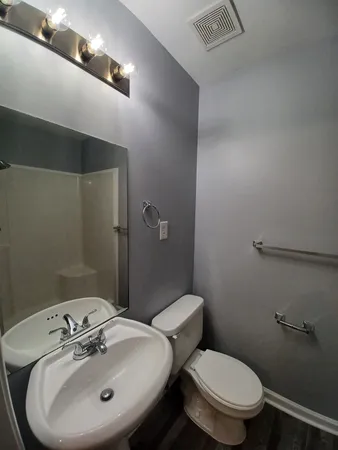 a bathroom with a sink and mirror with toilet