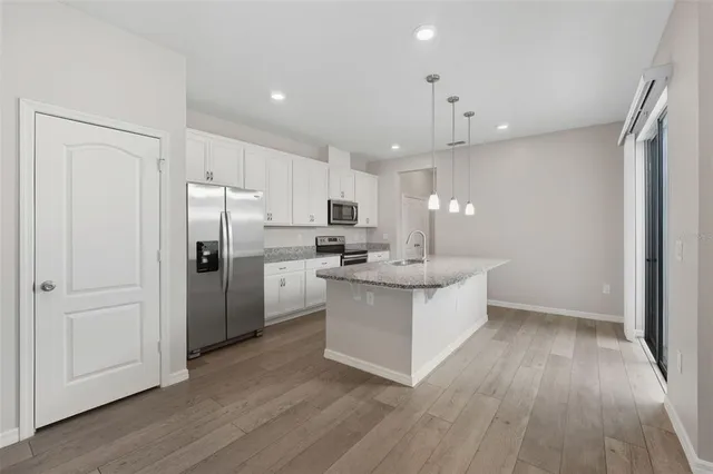 a kitchen with kitchen island white cabinets and stainless steel appliances