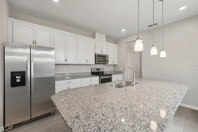 a kitchen with stainless steel appliances granite countertop a sink refrigerator and microwave