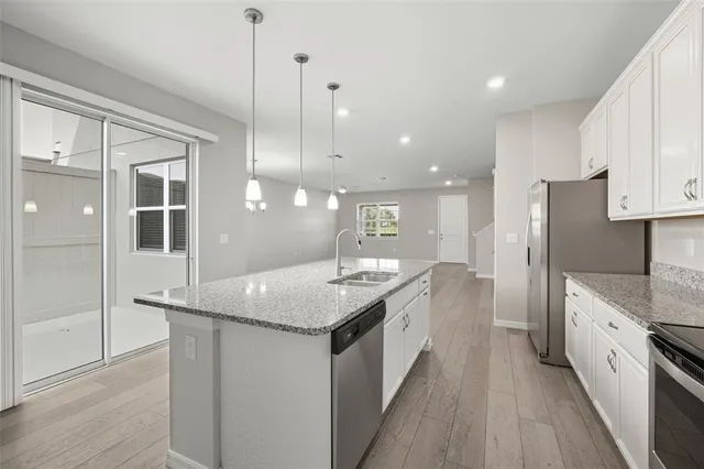 a kitchen with stainless steel appliances granite countertop a sink a refrigerator and a stove