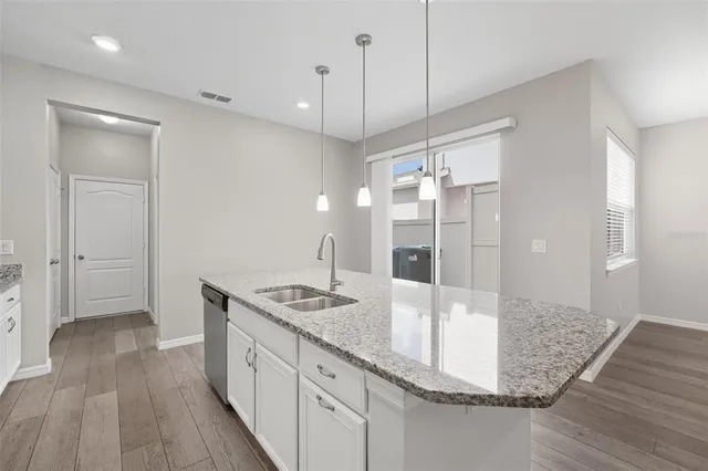 a bathroom with a granite countertop sink a mirror and shower