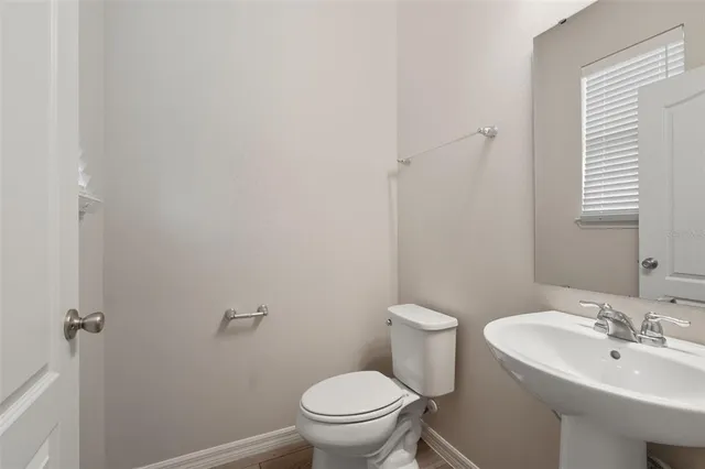 a bathroom with a sink a toilet and a mirror