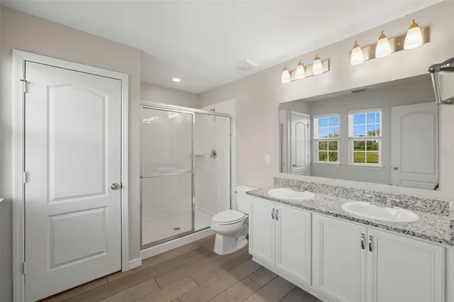 a bathroom with a granite countertop sink toilet and shower