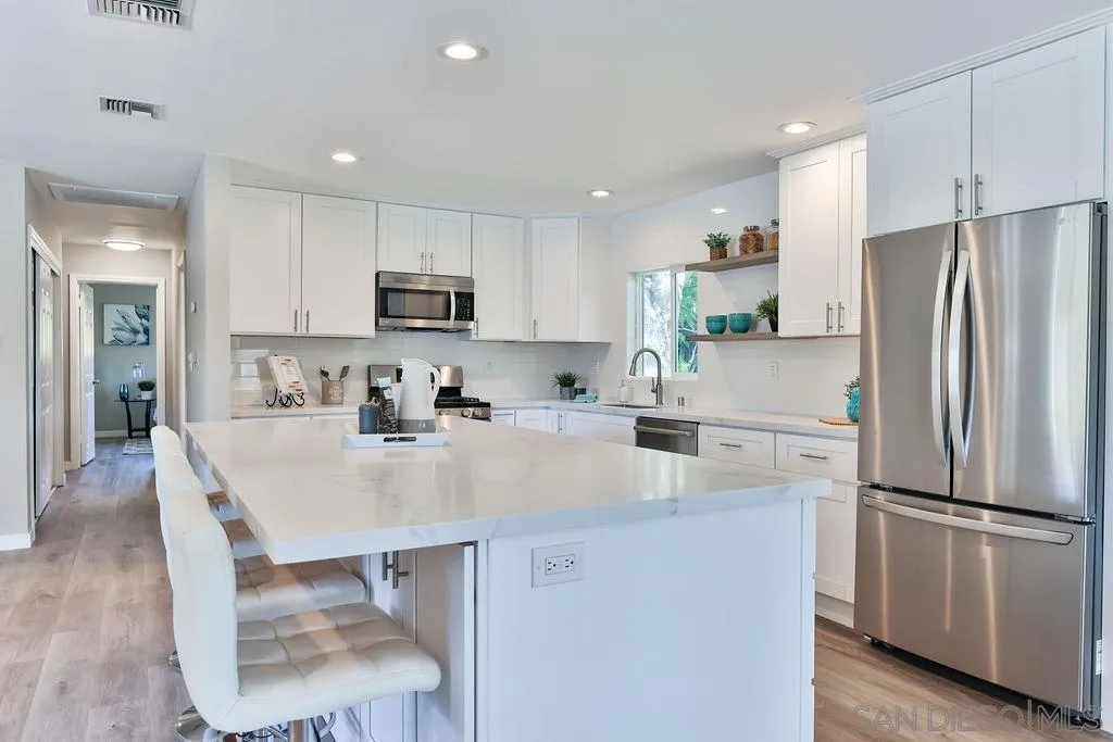 9802 Sierra Madre Road Spring Valley, CA 91977 - Photo 11 of 48 a kitchen with kitchen island a refrigerator stove and a sink with wooden floor