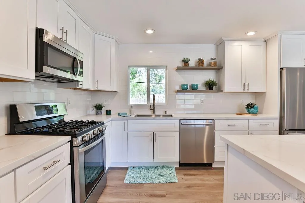 9802 Sierra Madre Road Spring Valley, CA 91977 - Photo 13 of 48 a kitchen with stainless steel appliances granite countertop a stove top oven a sink a microwave and refrigerator