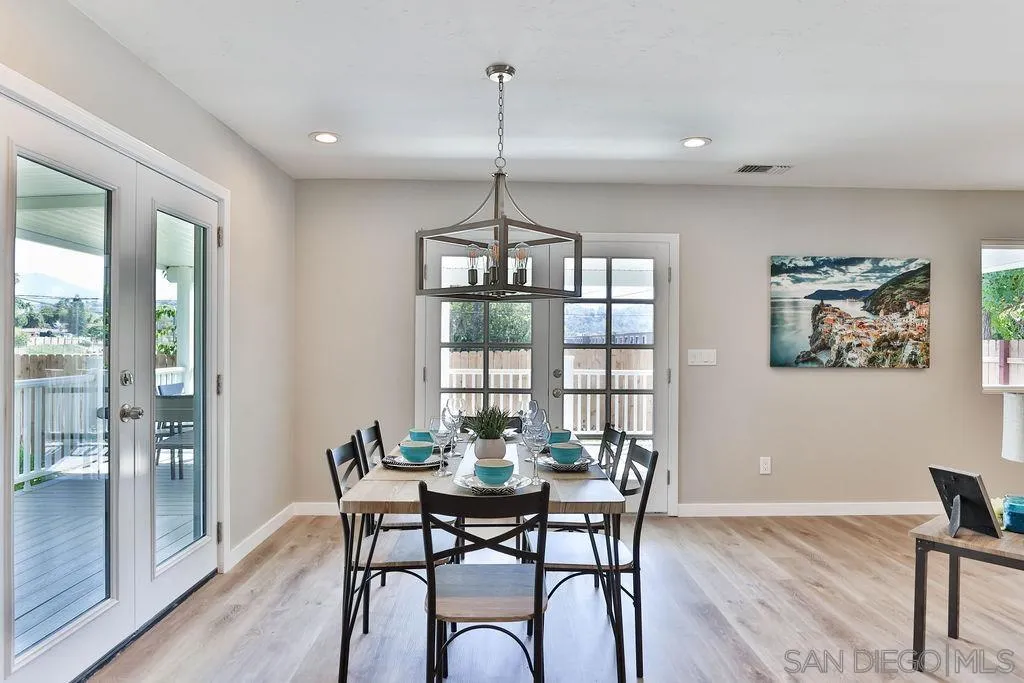 9802 Sierra Madre Road Spring Valley, CA 91977 - Photo 9 of 48 a dining room with furniture a chandelier and wooden floor
