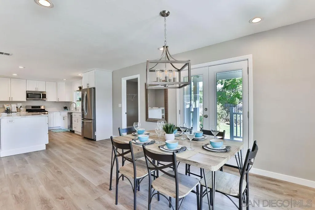 9802 Sierra Madre Road Spring Valley, CA 91977 - Photo 10 of 48 a view of a dining room with furniture a chandelier and wooden floor