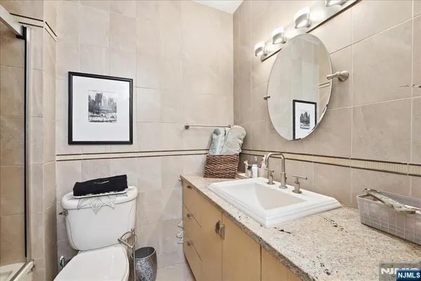 a bathroom with a granite countertop toilet sink and mirror