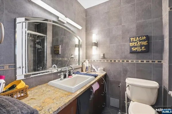 a bathroom with a granite countertop sink and a mirror