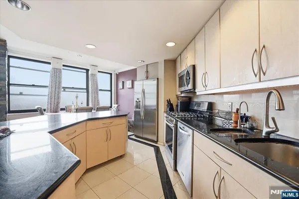 a kitchen with stainless steel appliances granite countertop a sink and cabinets