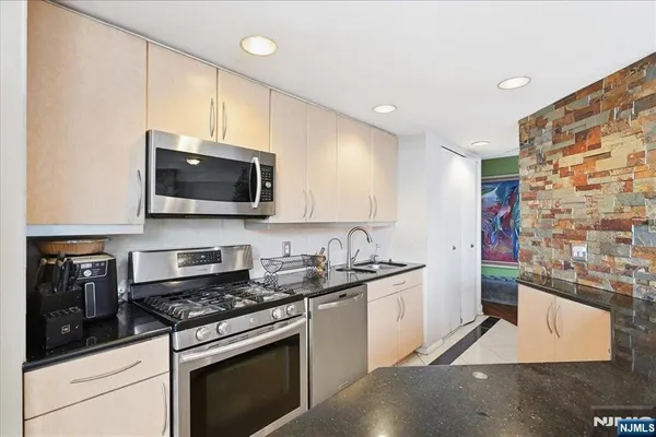 a kitchen with stainless steel appliances a sink a stove and microwave