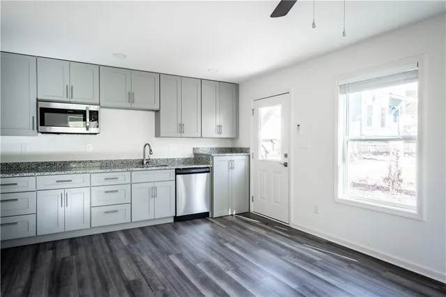 a kitchen with granite countertop white cabinets and white appliances