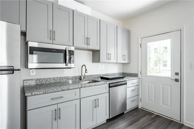 a kitchen with granite countertop white cabinets and white appliances