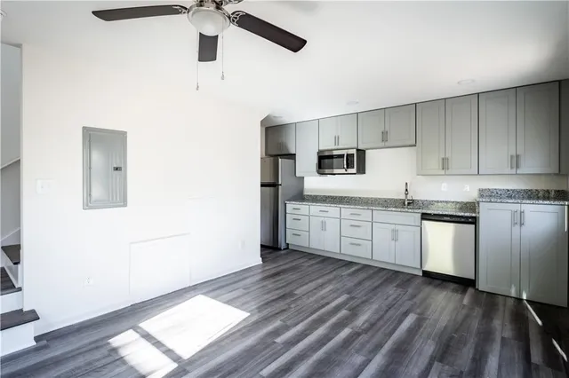 a kitchen with granite countertop white cabinets and white appliances