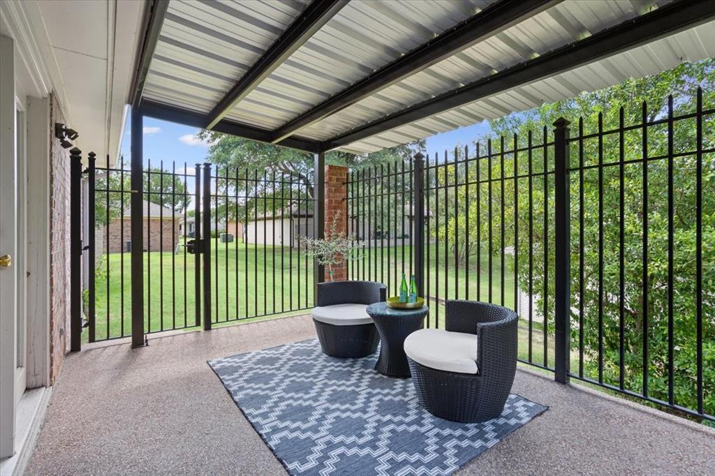 4108 Old Mill Road Waco, TX 76710 - Photo 32 of 39 Covered back patio with a corrugated metal roof and black metal fencing