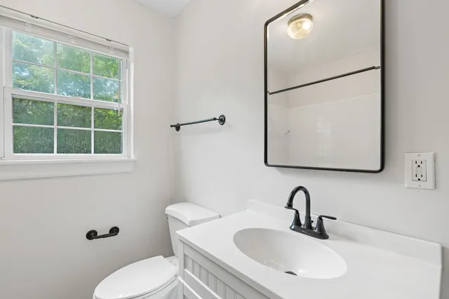 a bathroom with a sink mirror and toilet